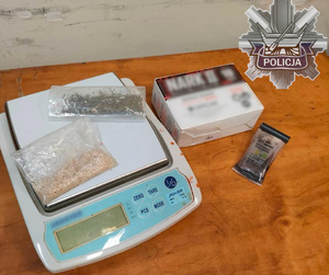 Zabezpieczone przez policjantów narkotyki na wadze, obok narkotest.