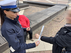 Policjantka wręcza odblaski seniorce.