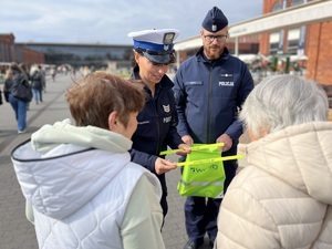 Policjanci wręczają odblaski seniorom.