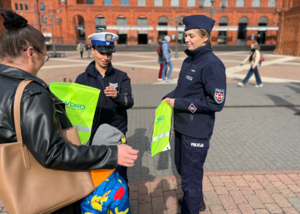 Policjantki wręczają odblaski dziecku.