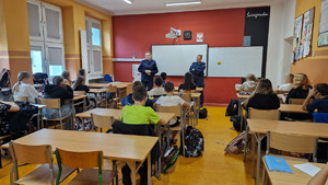 Umundurowane policjantki, w klasie, podczas zajęć z dziećmi.