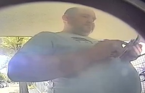 Mężczyzna stoi przy bankomacie.