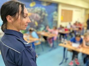 Dzieci rozwiązują test wiedzy pod nadzorem łódzkich policjantów.