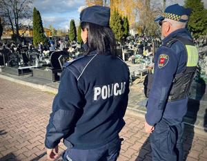 Policjant i strażnik ze Straży Miejskiej w Łodzi podczas kontroli cmentarza.