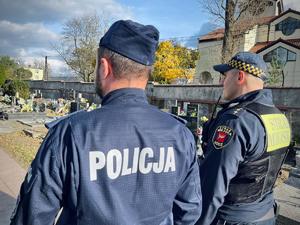 Policjant i strażnik ze Straży Miejskiej w Łodzi podczas kontroli cmentarza.