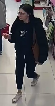 Kobieta w wieku około 25-30 lat, wzrost około 160 centymetrów, włosy do ramion koloru czarnego, szczupłej budowy ciała, ubrana w bluzę koloru czarnego, czarne spodnie brązową torebkę.