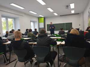 Policjant w czasie zajęć w klasie z młodzieżą.