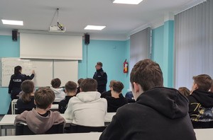 Policjanci, w klasie, podczas zajęć z młodzieżą.