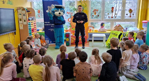 Policjant z Kotem Prewencjuszem rozmawiają z przedszkolakami o bezpieczeństwie.