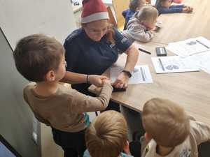 Policjantka pokazuje dzieciom jak pobierane są odciski palców.