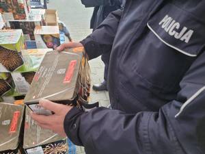 Policjant kontroluje stoisko z fajerwerkami.