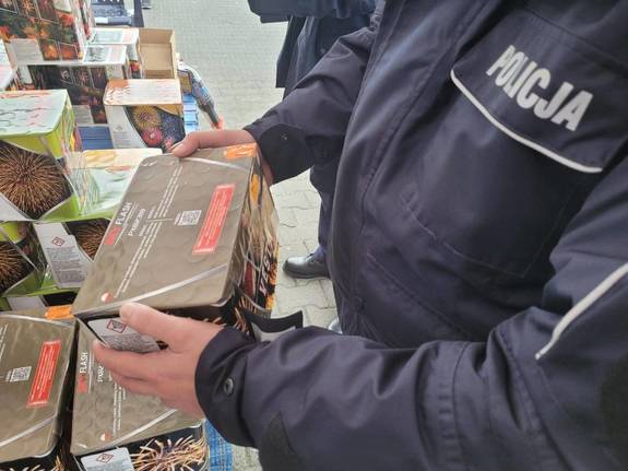 Policjant kontroluje stoisko z fajerwerkami.