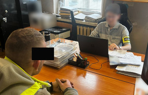 Policjant prowadzi czynności z zatrzymanym mężczyzną.