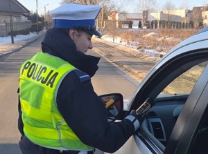 Policjantka kontroluje trzeźwość kierowcy.