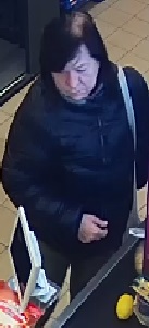 Kobieta miała na sobie ciemną kurtkę.