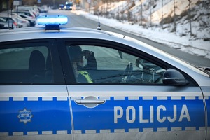 Funkcjonariusze w radiowozie obserwują ulice dojazdowe na stadion.