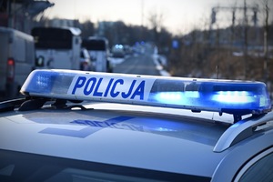 Napis policja na tle stadionu.