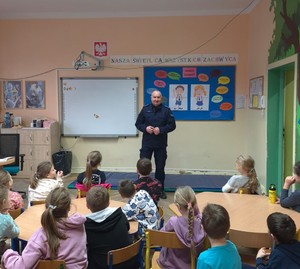 Policjant w klasie w trakcie zajęć z dziećmi.