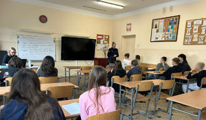 Policjantka rozmawia z młodzieżą w klasie.