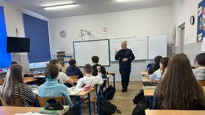 Policjantka rozmawia z młodzieżą w klasie.