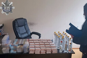 Zabezpieczone papierosy i alkohol leżą na stole.