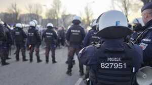 Policjanci zabezpieczają przejście kibiców na stadion.
