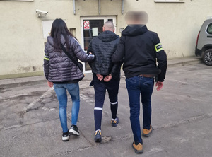 Zatrzymany prowadzony przez policjantów.