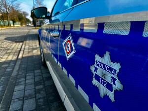 Oznaczenie Wydziału Ruchu Drogowego na drzwiach oznakowanego radiowozu policyjnego.