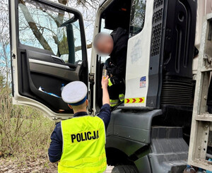 Policjant z Wydziału Ruchu Drogowego łódzkiej komendy w trakcie kontroli trzeźwości kierowcy ciężarówki.