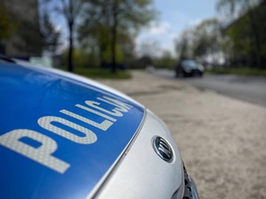 Radiowóz policyjny na tle stadionu.