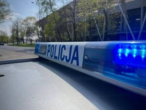 Radiowóz policyjny na tle stadionu.