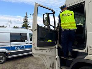Policjant kontroluje pojazd ciężarowy.