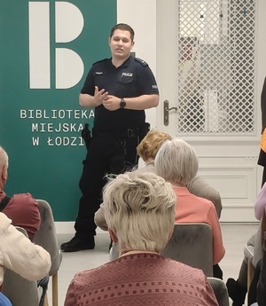 Dzielnicowy podczas prelekcji z seniorami.