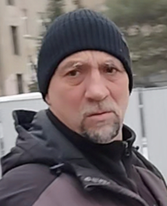Mężczyzna  w chwili zdarzenia ubrany był w czarną czapkę, czarno fioletową kurtkę, ciemne spodnie, normalnej budowy ciała, siwe włosy, ciemne oczy, zarost typu pełna kozia bródka.  Wiek około 50 lat.
