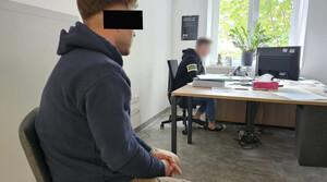 Policjant z zatrzymanym mężczyzną, w trakcie czynności.