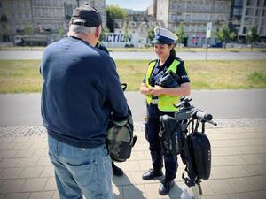 Policjanci w trakcie kontroli drogowej z kierującym hulajnogą elektryczną.