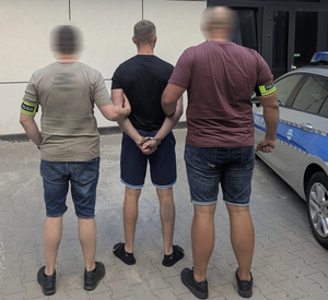 Policjanci prowadzą zatrzymanego.