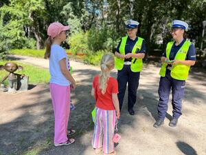 Policjantki z Wydziału Ruchu Drogowego Komendy Miejskiej Policji rozmawiają z dwiema dziewczynkami.