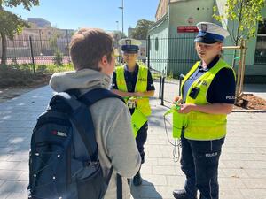Policjantki z Wydziału Ruchu Drogowego Komendy Miejskiej Policji w Łodzi wręczają elementy odblaskowe chłopcu.