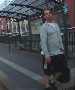 Mężczyzna w wieku około 30 lat, krępej budowy ciała, czarne włosy, wysokie czoło, ubrany był w czarne krótkie spodnie za kolano, czarne buty, biały t-shirt oraz szarą bluzę.