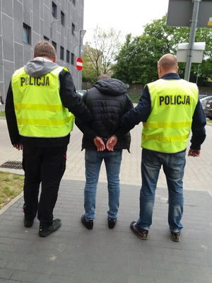 policjanci prowadzą zatrzymanego