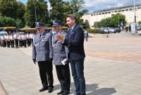 Komendant Wojewódzki Policji i Komendant Miejski Policji w Łodzi oraz Prezes Stowarzyszenia Rodzina Policyjna stoja przodem do gości na Placu Dąbrowskiego.