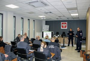 Zdjęcie przedstawia policjantów prowadzących prelekcję dla funkcjonariuszy Służby Więziennej.