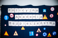 Obrazek przestawiający napis na granatowym tle zestawiony z poszczególnych liter jako logo Policyjnej Akademi Bezpieczeństwa